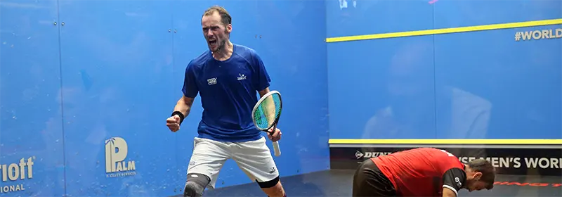 A professional squash players celebrates a win