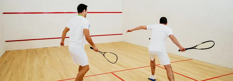 Two beginners playing squash