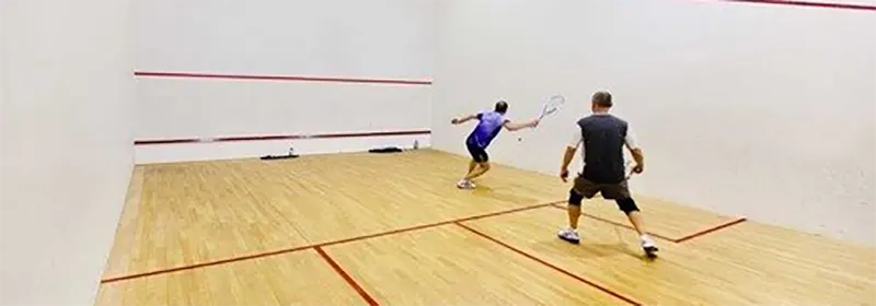 Two squash players during the middle of a rally