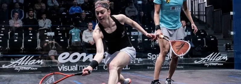 Two women playing squash