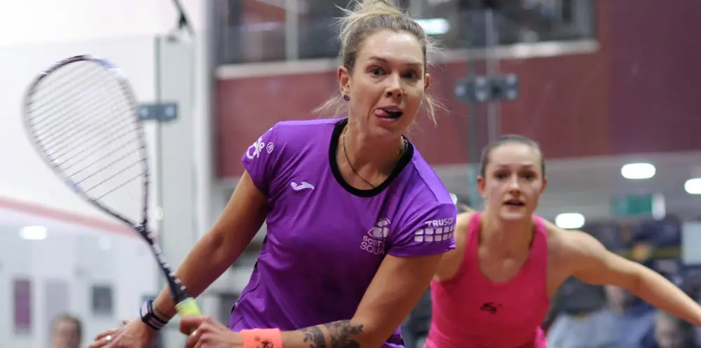 two female squash players trying to win the point.