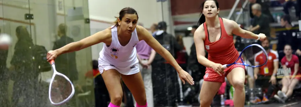 Two female squash plaeyrs on the glass court