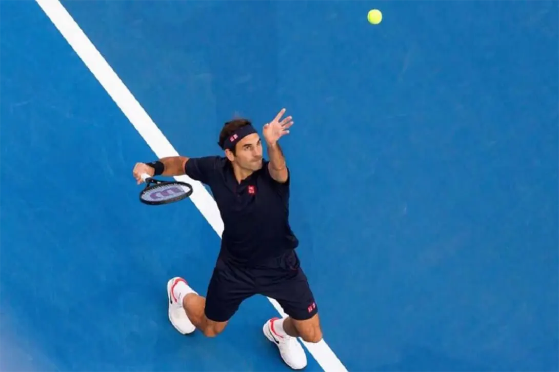 Roger Federer serves a tennis ball