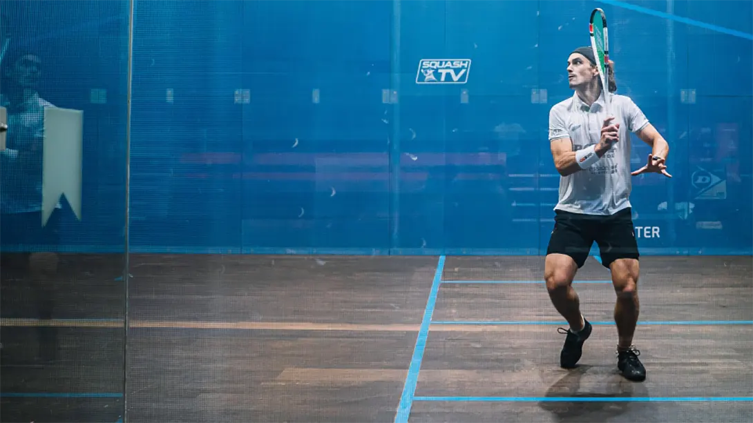 Paul Coll practicing on an all-glass squash court