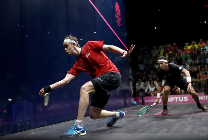 James Wilstrop about to flick a forehand shot somewhere on the squash court