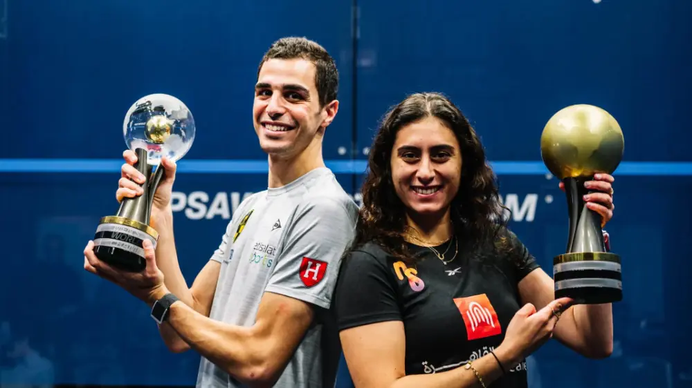 World Squash Champion holding their trophies