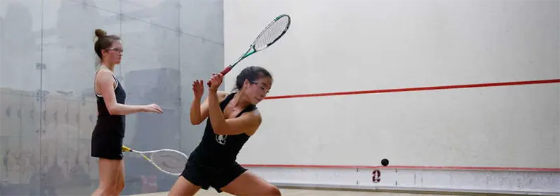 Two women playing squash