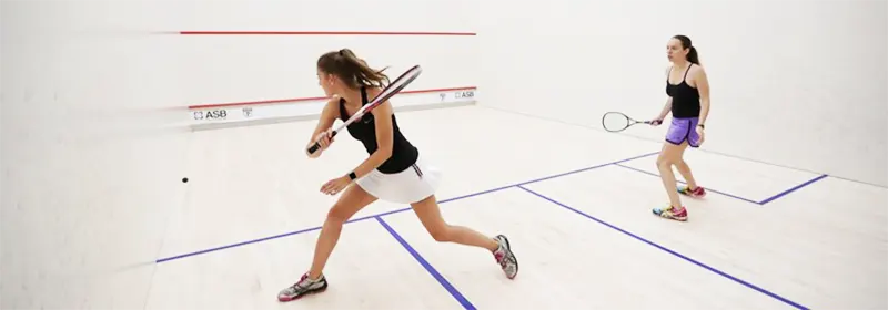 Two women playing squash