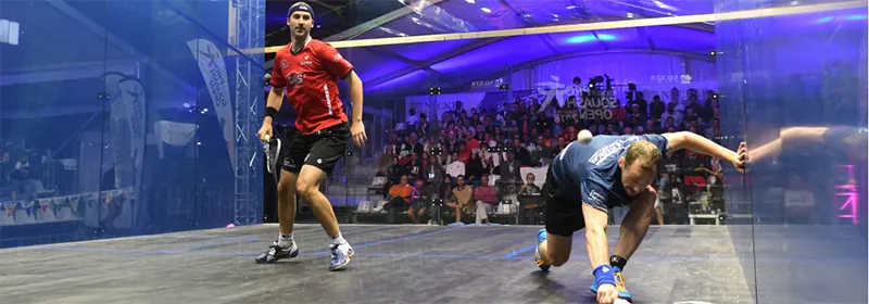 Two male professional squash players on an all-glass court