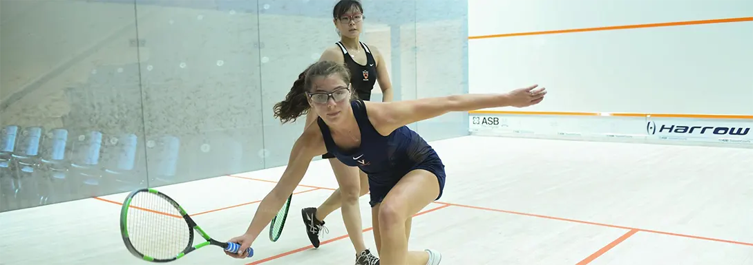 A female squash player getting down low to play the ball