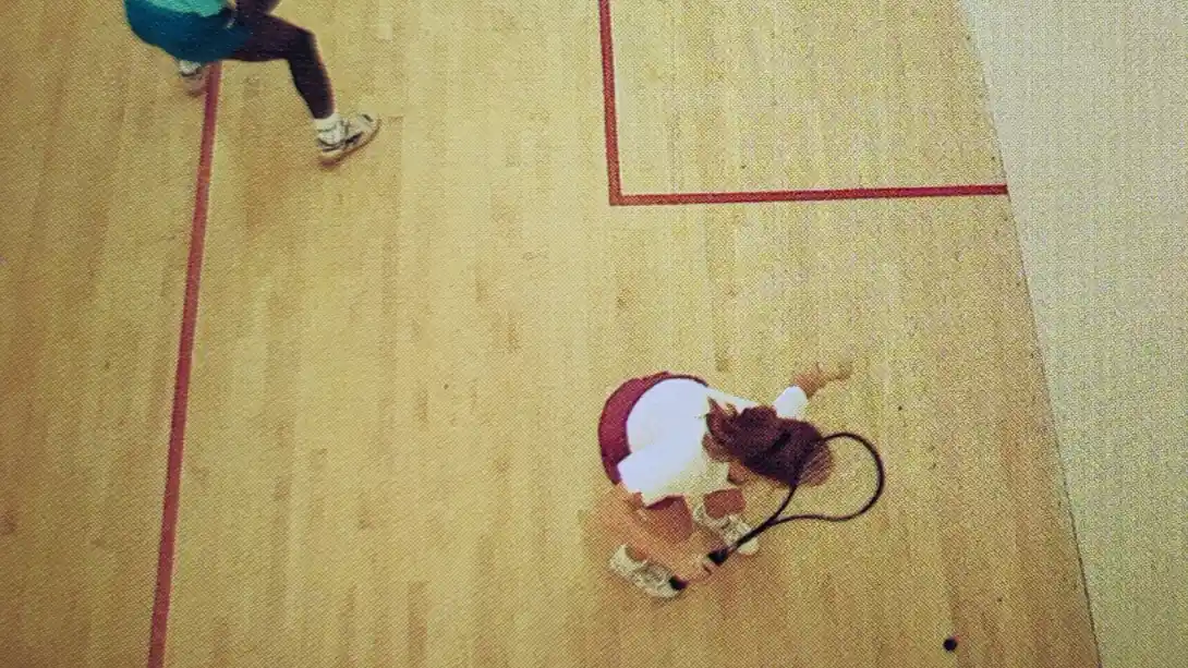 Two squash players playing the alley game on the right side of the squash court