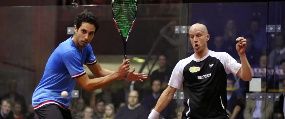Two male squash players focused on the match