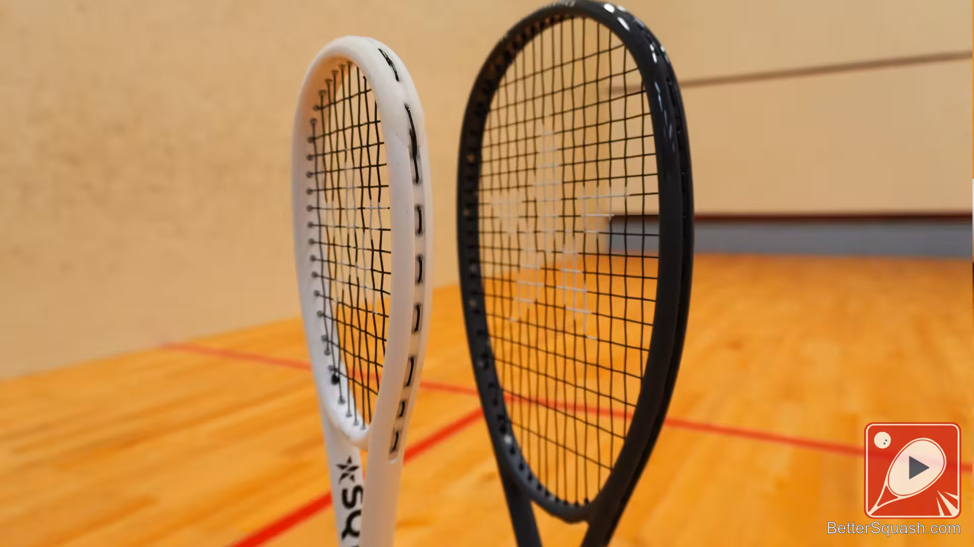 Master Athletics Squash Training Racket, showing a comparison of the head size with the rackets standing on a squash court floor