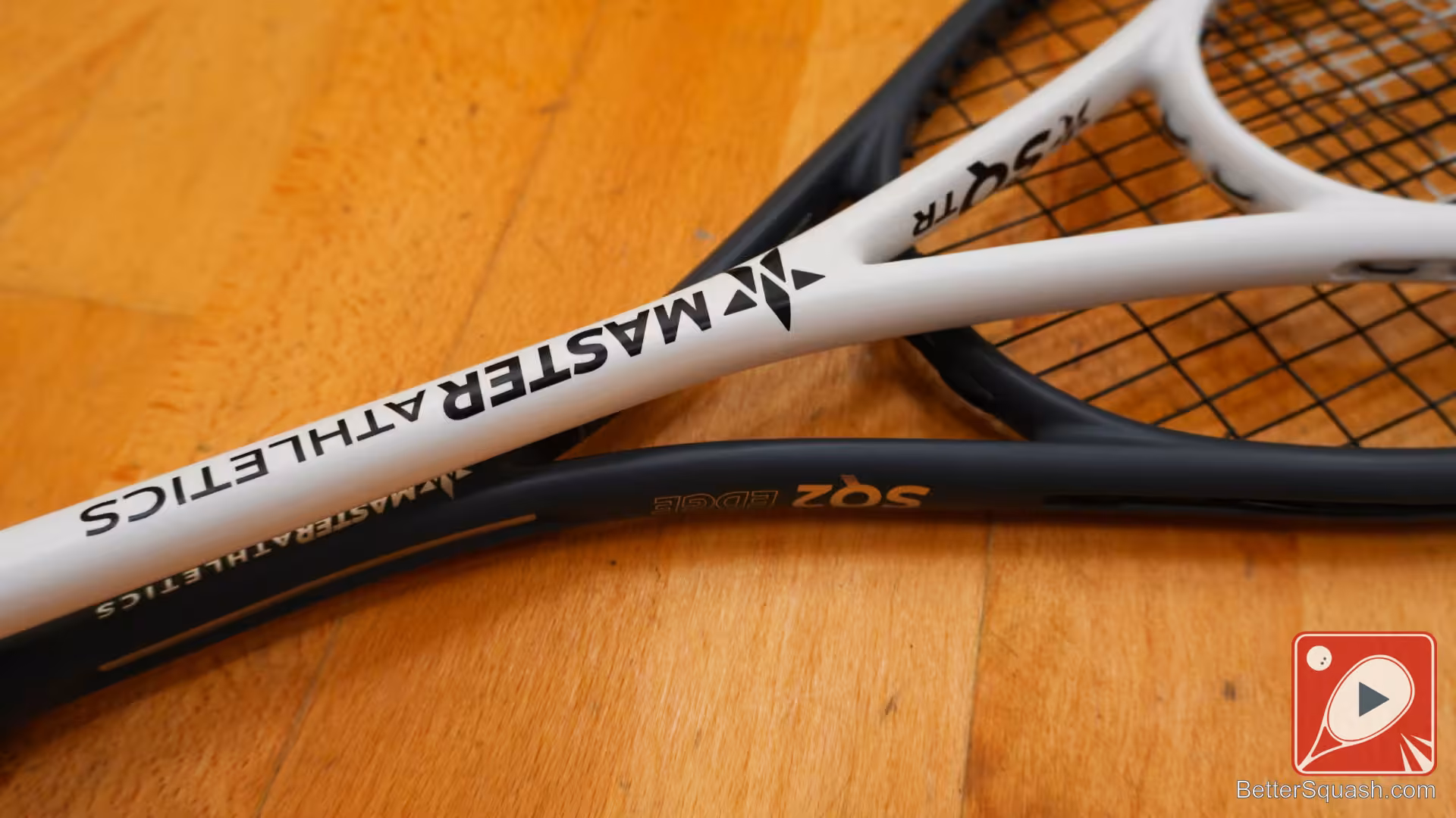 A close up of the Master Athletics Squash Training Racket throat area compared to a normal modern squash racquet