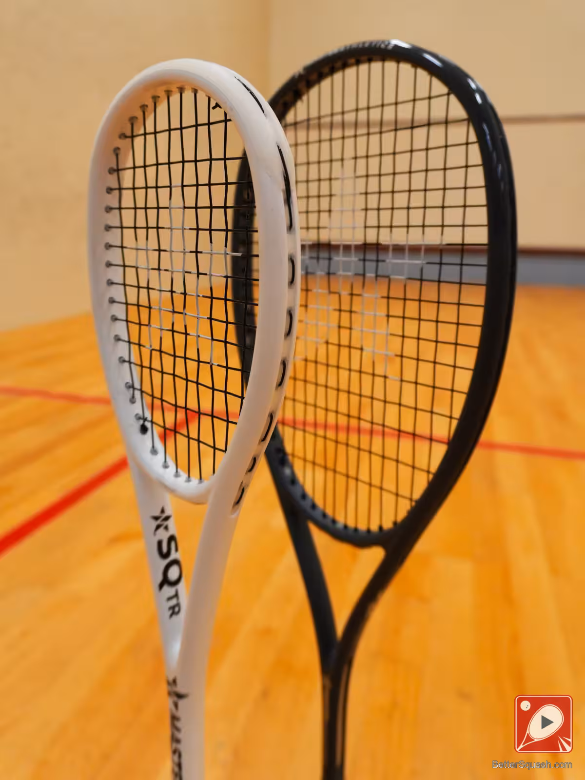 Two Master Athletics Squash Racquets standing new each other comparing head shape and size