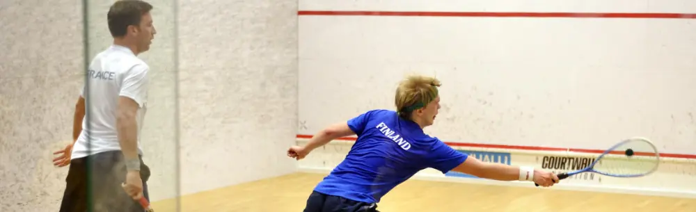 Two male professional squash playing in the middle of a rally